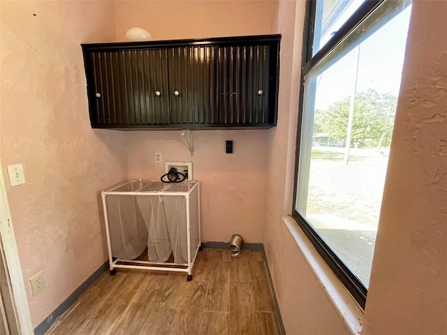 laundry room with a wealth of natural light, cabinets, light wood-type flooring, and hookup for a washing machine