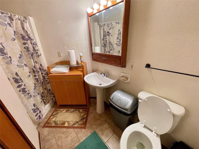 bathroom featuring a shower with shower curtain, tile patterned flooring, and toilet