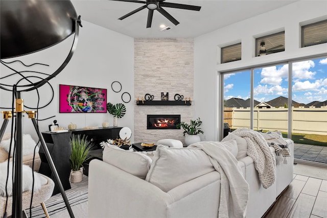 living room with a fireplace and ceiling fan