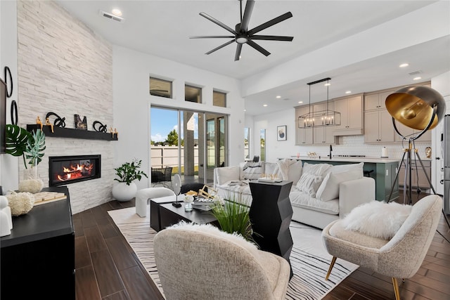 living room with a fireplace and ceiling fan