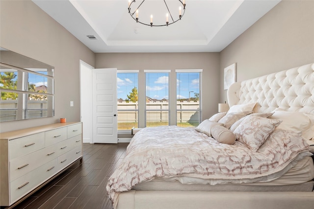 bedroom with an inviting chandelier and a tray ceiling