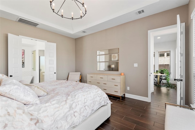 bedroom with a raised ceiling and a chandelier