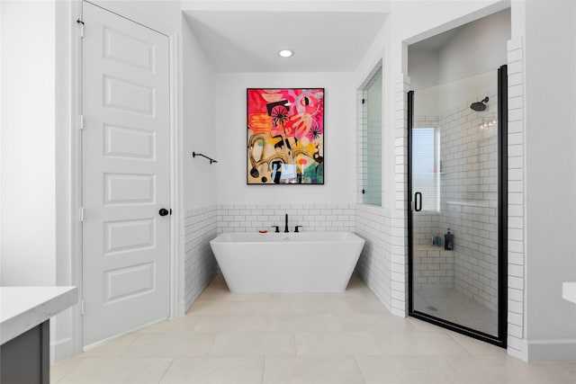 bathroom featuring tile patterned floors, shower with separate bathtub, and tile walls