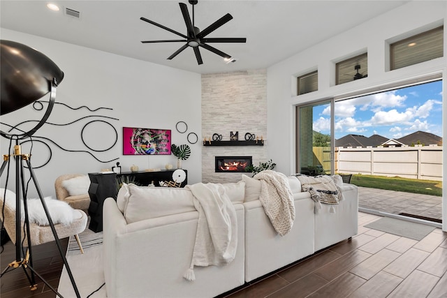 living room featuring a fireplace and ceiling fan