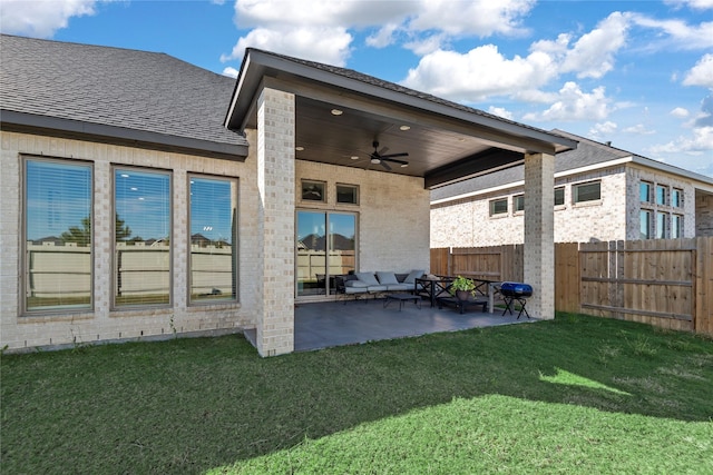 rear view of house featuring ceiling fan, a yard, and a patio