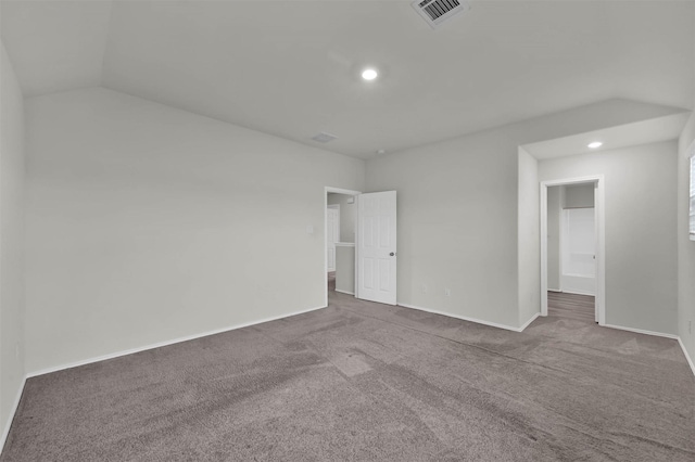 carpeted spare room featuring vaulted ceiling