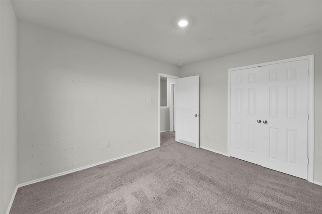 unfurnished bedroom featuring carpet and a closet