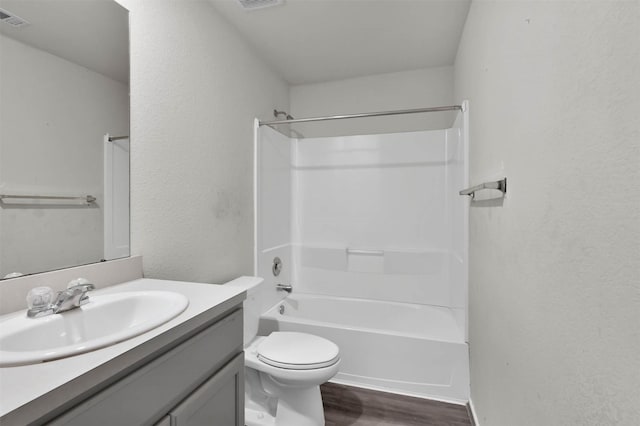 full bathroom with hardwood / wood-style floors, vanity, toilet, and washtub / shower combination