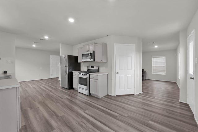 kitchen featuring appliances with stainless steel finishes, light hardwood / wood-style floors, and gray cabinetry