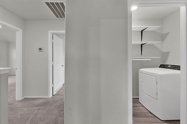 laundry room featuring light colored carpet and washer / dryer