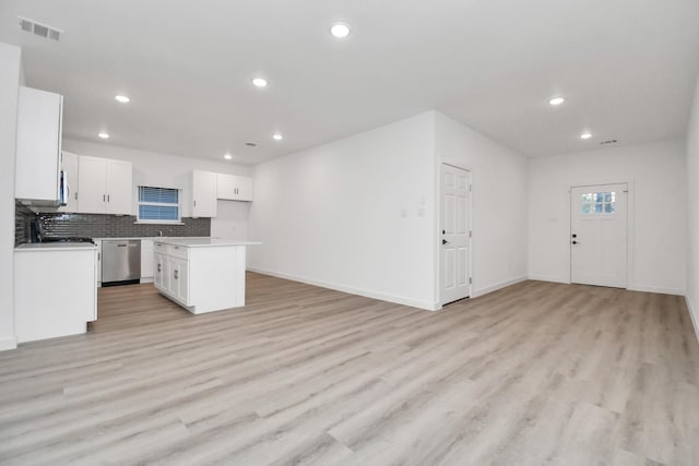 kitchen featuring stainless steel dishwasher, a kitchen island, light wood-type flooring, and white cabinetry