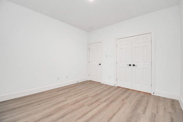 unfurnished bedroom with light wood-type flooring and a closet