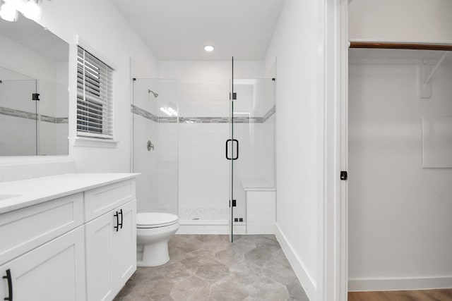 bathroom featuring vanity, toilet, and an enclosed shower