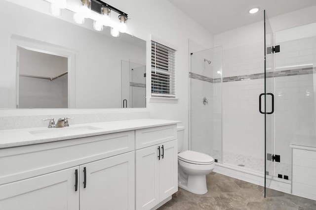 bathroom featuring vanity, toilet, and walk in shower