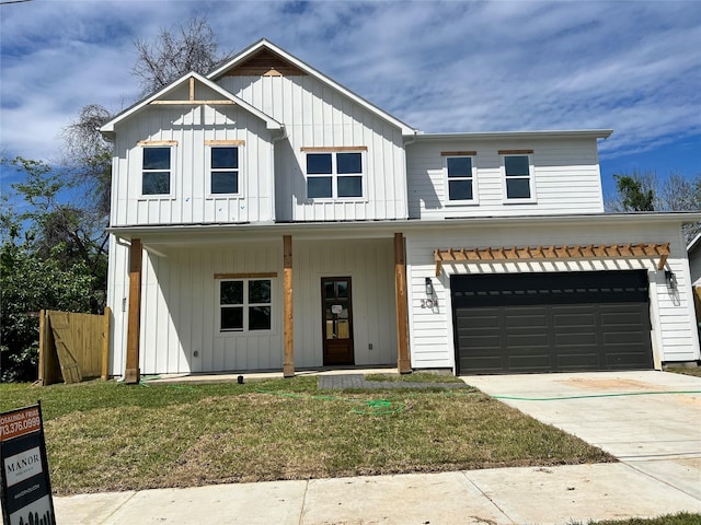 modern farmhouse featuring a front lawn, covered porch, and a garage