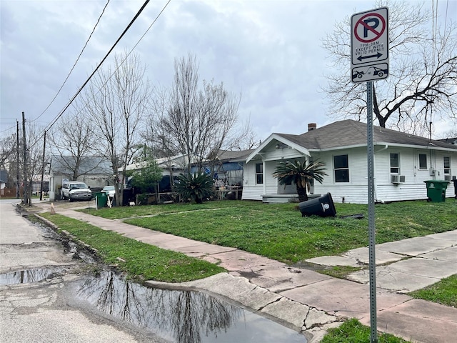 view of front of property with a front lawn and cooling unit