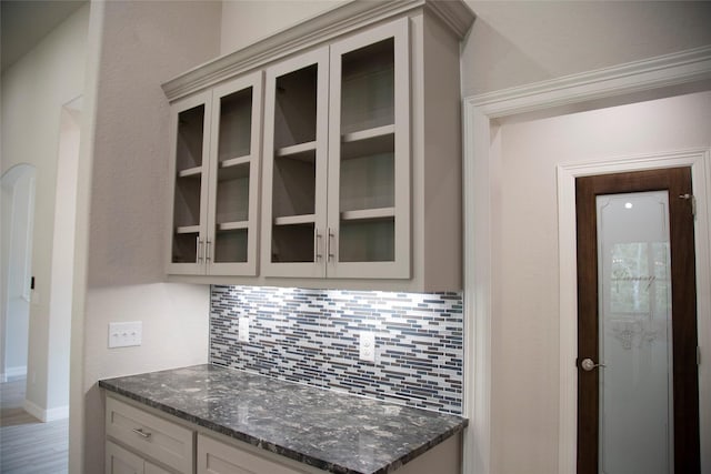 kitchen with decorative backsplash and dark stone countertops