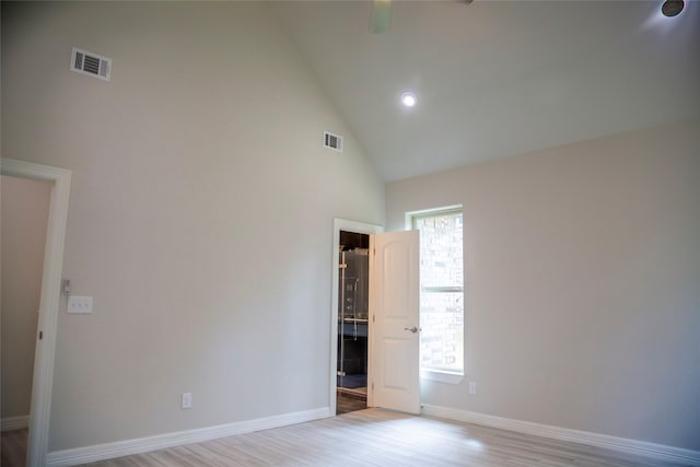 unfurnished room with light hardwood / wood-style flooring and high vaulted ceiling