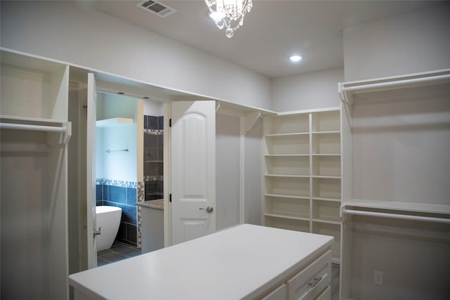 walk in closet featuring a notable chandelier