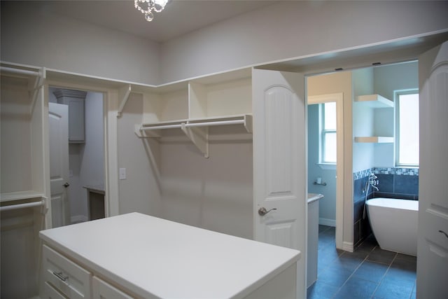 walk in closet with dark tile patterned floors