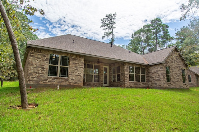 back of house featuring a lawn and ceiling fan