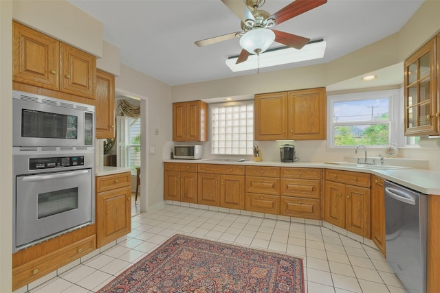 kitchen with light tile patterned flooring, appliances with stainless steel finishes, ceiling fan, and sink