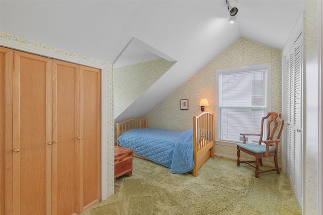 bedroom with light colored carpet and lofted ceiling