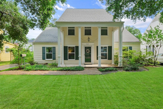 neoclassical / greek revival house featuring a shingled roof and a front yard