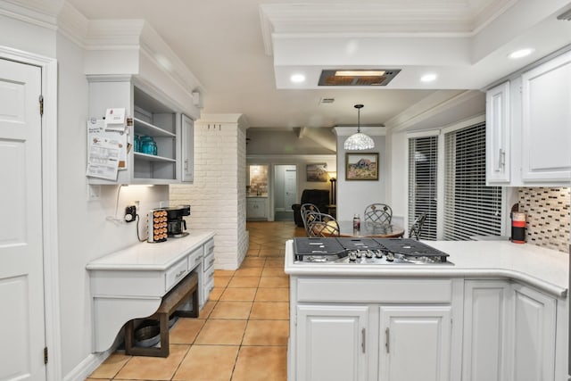 kitchen with kitchen peninsula, tasteful backsplash, pendant lighting, white cabinets, and stainless steel gas stovetop