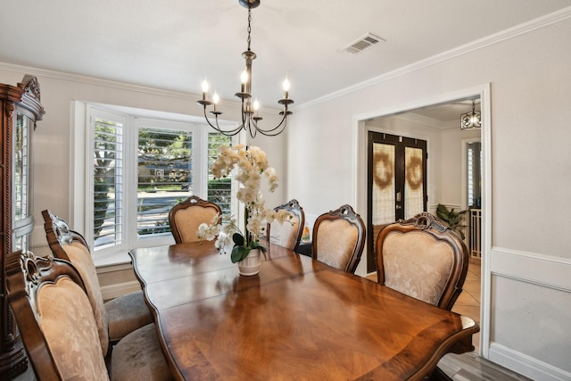 dining room with a chandelier, french doors, and ornamental molding