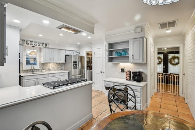 kitchen with sink, tasteful backsplash, stainless steel fridge, crown molding, and light tile patterned floors