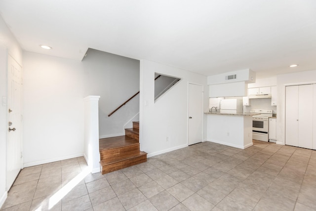 unfurnished living room with light tile patterned floors and sink