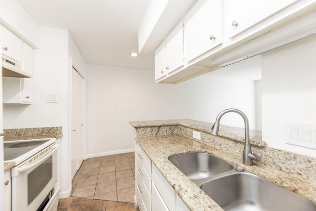 kitchen with white cabinets, light stone counters, white electric stove, and sink