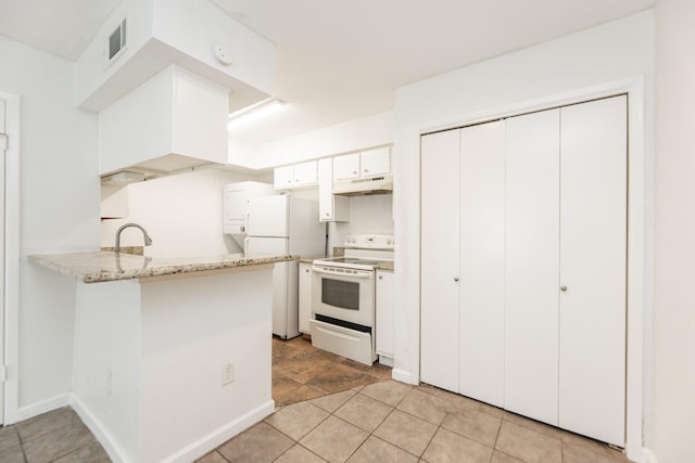 kitchen featuring white appliances, sink, kitchen peninsula, light tile patterned floors, and white cabinetry