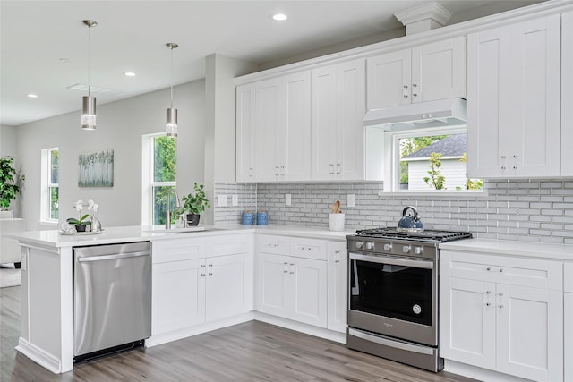 kitchen with sink, white cabinetry, stainless steel appliances, and hanging light fixtures