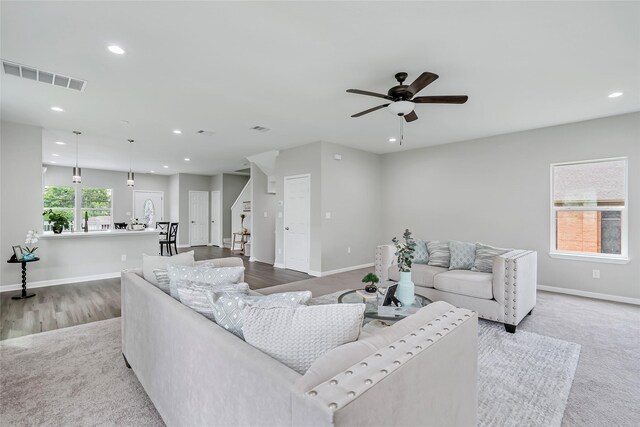 carpeted living room with ceiling fan