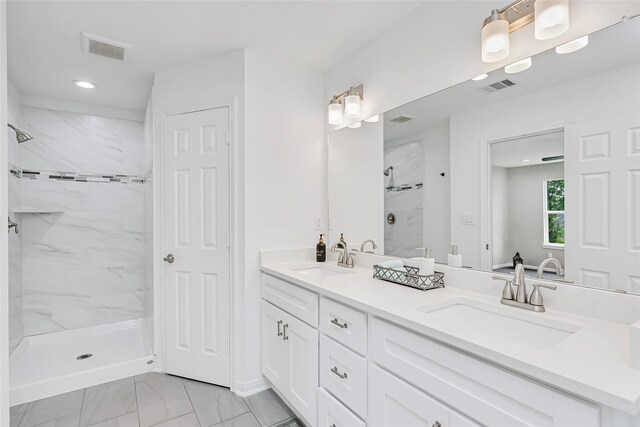 bathroom featuring a tile shower and vanity