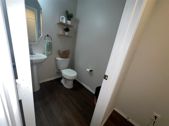 bathroom with wood-type flooring, toilet, and sink