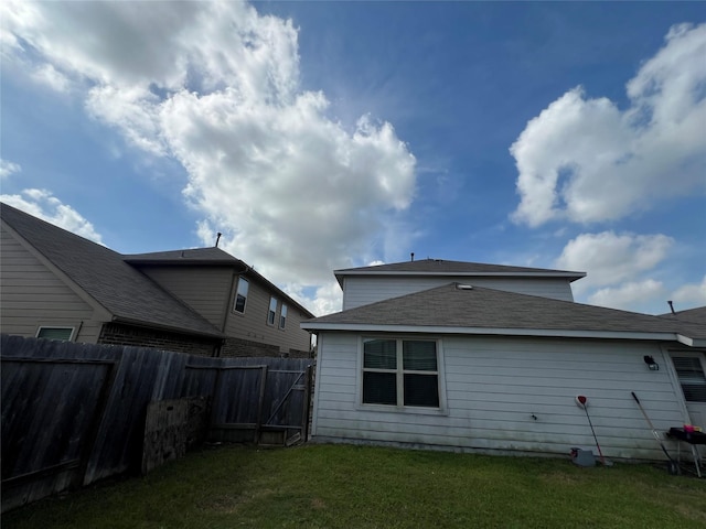 rear view of house featuring a yard