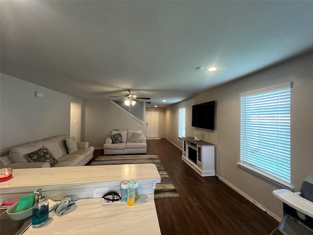 living room with dark hardwood / wood-style floors and ceiling fan