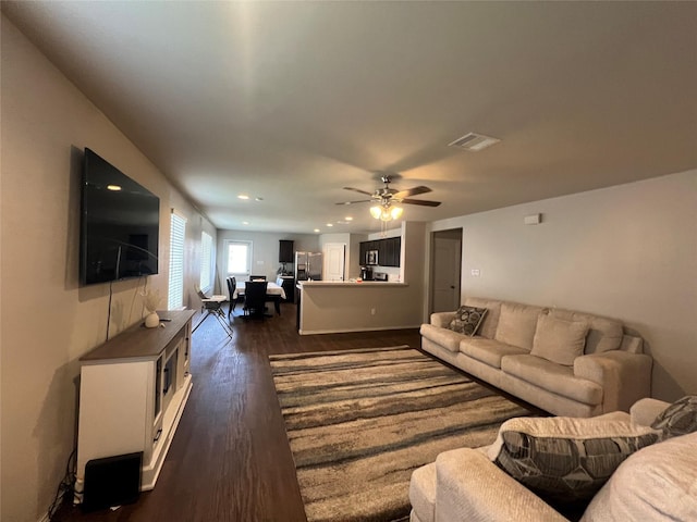 living room with dark hardwood / wood-style flooring and ceiling fan