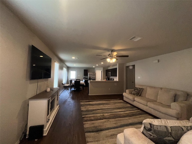 living room featuring dark hardwood / wood-style flooring and ceiling fan