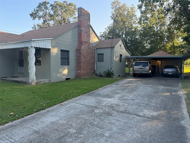 view of side of home with a carport and a lawn