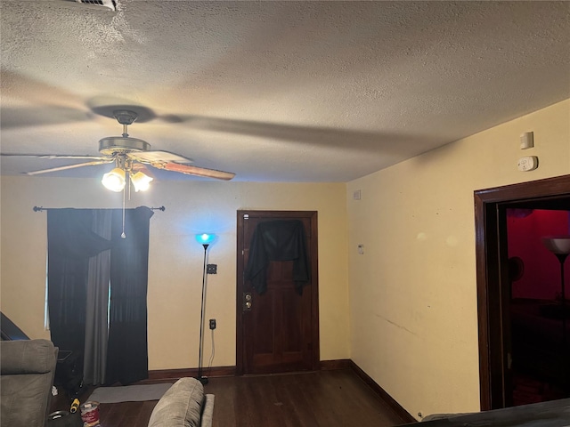 interior space with dark hardwood / wood-style floors, ceiling fan, and a textured ceiling