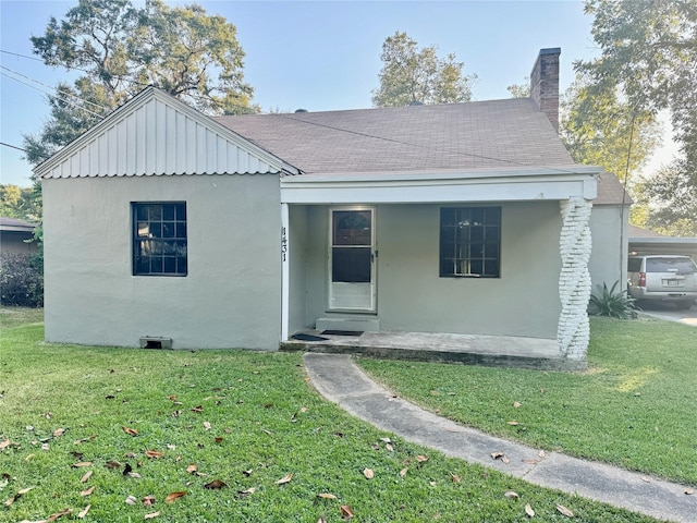 bungalow with covered porch and a front yard