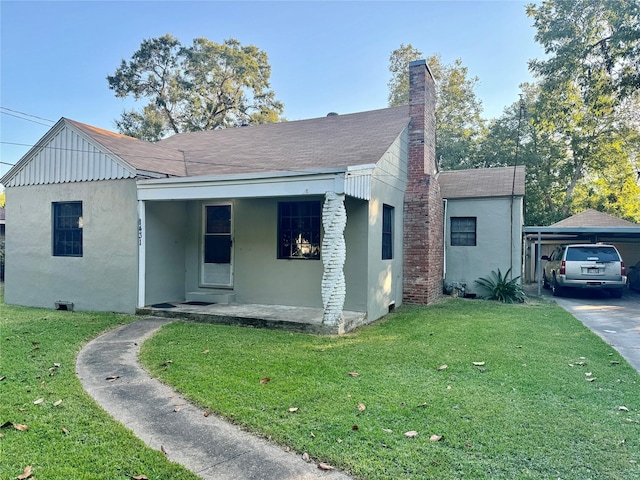 view of front of home with a front yard, stucco siding, roof with shingles, and a chimney