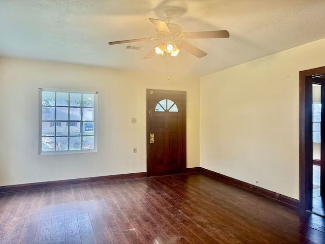 entryway featuring ceiling fan, dark wood-type flooring, and a textured ceiling