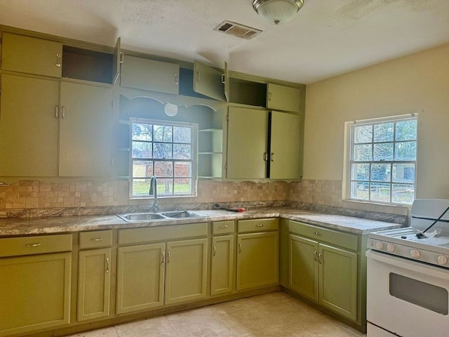 kitchen featuring sink, white gas range oven, and tasteful backsplash