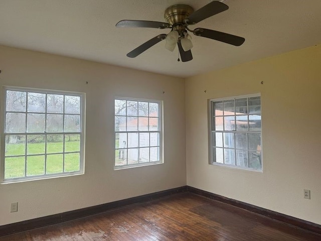 empty room featuring a healthy amount of sunlight and dark hardwood / wood-style floors