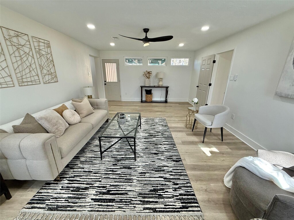 living room with ceiling fan and light hardwood / wood-style flooring